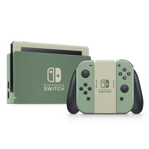 Op de afbeelding: Een groene en beige Nintendo Switch-console met twee controllers. De console heeft het Nintendo Switch-logo en de tekst "Nintendo Switch" aan de voorkant. De controllers hebben het Nintendo Switch-logo en de tekst "Nintendo Switch" aan de voorkant.