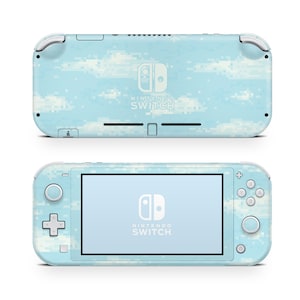 Puede incluir: Una consola Nintendo Switch Lite de color azul claro con un diseño de nubes pixeladas. La parte frontal presenta una pantalla con el logotipo de Nintendo Switch, y la parte trasera también muestra el logotipo. La consola tiene una cruceta, botones y joysticks.