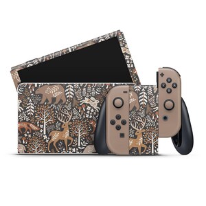 Op de afbeelding: Een bruine en beige Nintendo Switch console en twee controllers met een bosdierpatroon. Het patroon bevat herten, beren, konijnen en bomen.