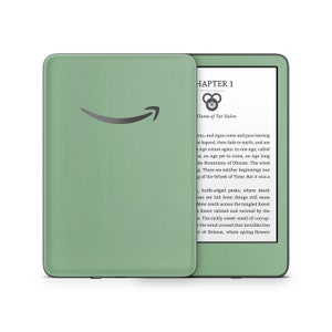 Puede incluir: Un lector electrónico Kindle Paperwhite verde con un marco negro. La pantalla muestra el texto "CHAPTER 1" y "Flame of Tar Valon".