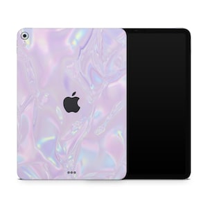May include: A white iPad case with a holographic iridescent design. The case has a cutout for the Apple logo and a camera lens.