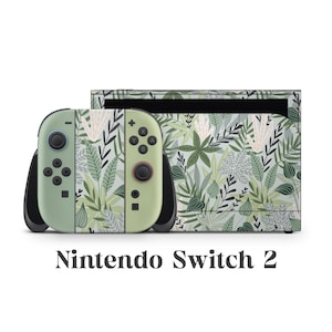 May include: A Nintendo Switch 2 console and controllers with a green and white botanical leaf pattern. The controllers are light green with black detailing. The text "Nintendo Switch 2" is displayed below the console.