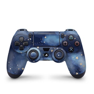 Peut inclure: Une manette de jeu PlayStation 4 bleue et dorée avec un motif de nuit étoilée. La manette a un pavé directionnel noir, des boutons de face et des sticks analogiques.
