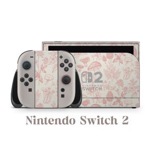 May include: A Nintendo Switch 2 console and controllers featuring a cream and pink floral and mushroom design. The text "Nintendo Switch 2" is displayed below the console.