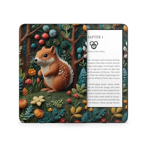 May include: A Kindle e-reader with a colorful, illustrated cover featuring a squirrel in a forest setting. The text on the screen reads "Chapter 1 Flame of Tar Valon".