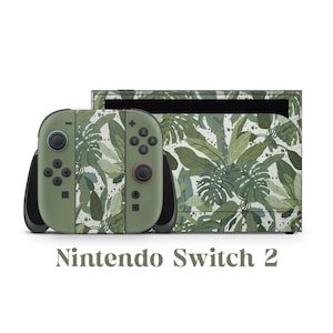 May include: A Nintendo Switch 2 console and controllers featuring a green and white tropical leaf design. The controllers have black detailing and coloured buttons. The text "Nintendo Switch 2" is printed below the console.