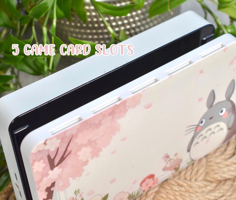 May include: A white and pink game card case with a Totoro character design. The case has 5 game card slots and the text "5 GAME CARD SLOTS" is printed on the top.