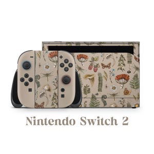 May include: A Nintendo Switch 2 console with a beige skin featuring a botanical pattern of mushrooms, dragonflies, and flowers. The text "Nintendo Switch 2" is displayed below the console.