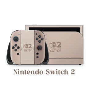 Może przedstawiać: Beżowo-biała konsola Nintendo Switch 2 z pasującymi kontrolerami. Konsola i kontrolery mają czarne akcenty i przyciski. Tekst "Nintendo Switch 2" jest wydrukowany poniżej.