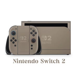 Könnte beinhalten: Eine taupefarbene Nintendo Switch 2 Konsole und Controller. Die Controller haben schwarze Akzente und farbige Knöpfe. Die Konsole und die Controller tragen das Nintendo Switch Logo und die Zahl 2. Der Text "Nintendo Switch 2" steht darunter.
