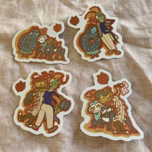 May include: Four die-cut stickers featuring cartoon couples in various embraces. The stickers have a white border and a warm color palette with shades of brown, orange, blue, and green. Each sticker includes a heart-shaped design element.