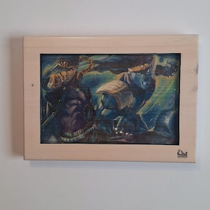 May include: Artwork of two figures in a wooden frame. The figures are depicted in a dynamic pose with vibrant colors, set against a dark background. The artwork is framed in a natural wood finish.