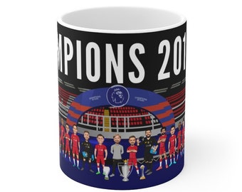 Könnte beinhalten: Eine schwarze und blaue Keramiktasse mit einem weißen Design, auf dem "CHAMPIONS 2019" steht und eine Cartoon-Illustration einer Fußballmannschaft mit Trophäen zu sehen ist.