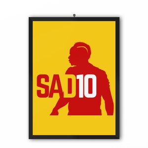 May include: A yellow poster with a red silhouette of a soccer player with the text "SAD10" in white.