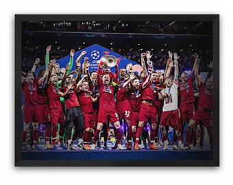 Könnte beinhalten: Gerahmter Druck, der eine Fußballmannschaft in Rot zeigt, die einen Sieg feiert und eine Trophäe hochhält. Das Bild spielt in einem Stadion, mit den Worten "Champions League" im Hintergrund.