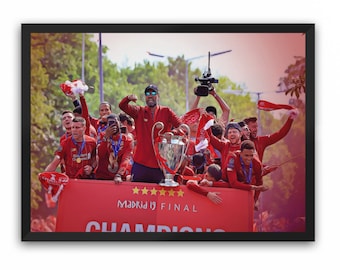 Könnte beinhalten: Eine Gruppe von Menschen in roten Uniformen feiert auf einem roten Bus mit einer großen Trophäe. Der Bus hat fünf Sterne und den Text "Madrid 19 FINAL" an der Seite. Die Menschen halten die Trophäe hoch und winken mit Fahnen.