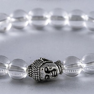May include: A clear quartz crystal beaded bracelet with a silver Buddha charm.