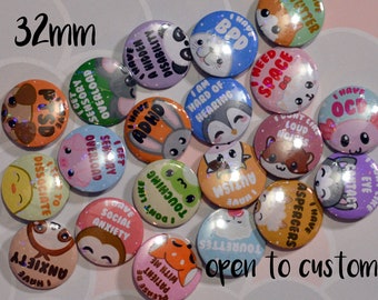 May include: A collection of circular 32mm pin-back buttons featuring various cartoon animals and text related to mental health and disabilities. The buttons display phrases like I Have ADHD, I Have Autism, I Have Social Anxiety, and I Have OCD.