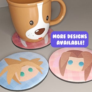 May include: Three round coasters featuring different cartoon character designs. The coasters are made from a soft, absorbent material. The text "MORE DESIGNS AVAILABLE!" is printed on a purple rectangle.