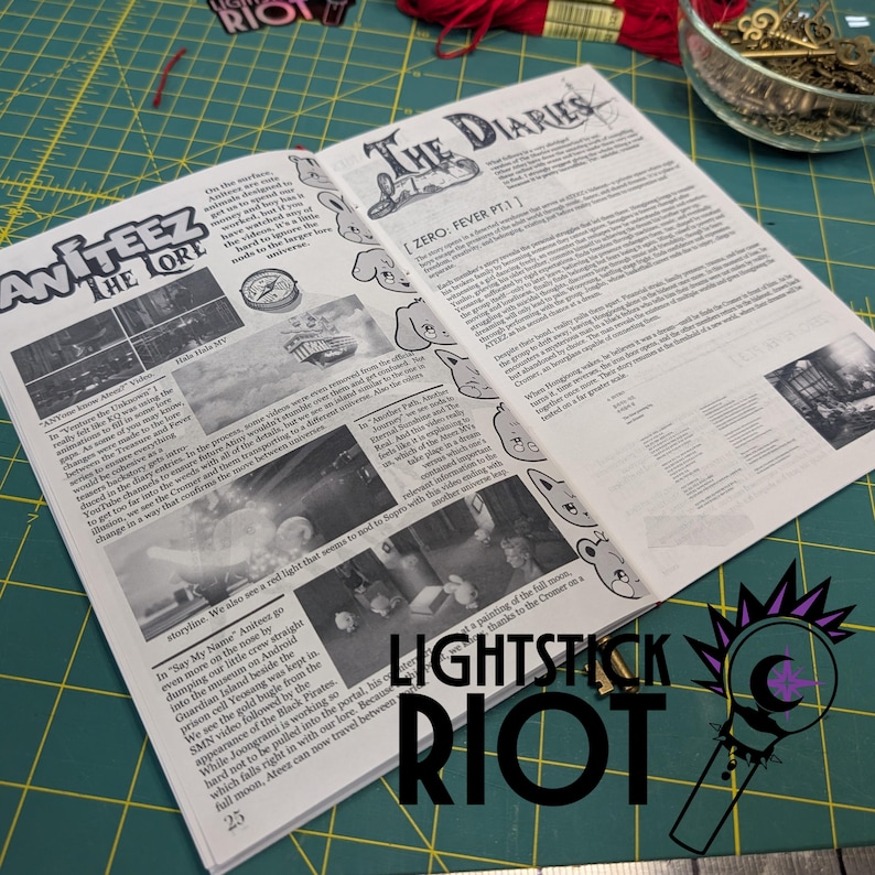 Puede incluir: Peri&oacute;dico abierto con los titulares "ANITEEZ THE LORE" y "THE DIARIES". Las p&aacute;ginas est&aacute;n llenas de texto e ilustraciones. La esquina inferior derecha tiene el texto "LIGHTSTICK RIOT" y un logotipo. El peri&oacute;dico est&aacute; sobre una esterilla de corte verde.