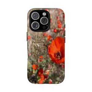 May include: A phone case featuring a vibrant red poppy flower with water droplets. The background shows a field of poppies. The case includes the text "I waited patiently for The Lord; He Turned to me and Heard my Cry. Psalm 40:1."