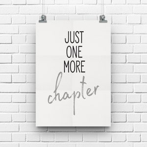May include: A white poster with black text that reads "Just One More Chapter" in a gray, handwritten font.