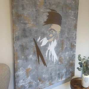 May include: Abstract painting on canvas featuring a stylized portrait of a person with a beard. The background is a textured gray with brown and white accents.