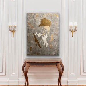 May include: A gold and white abstract portrait painting of a person with a beard and a hat. The painting is on a textured canvas and has a gray background.