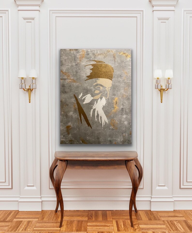May include: A gold and white abstract portrait painting of a person with a beard and a hat. The painting is on a textured canvas and has a gray background.