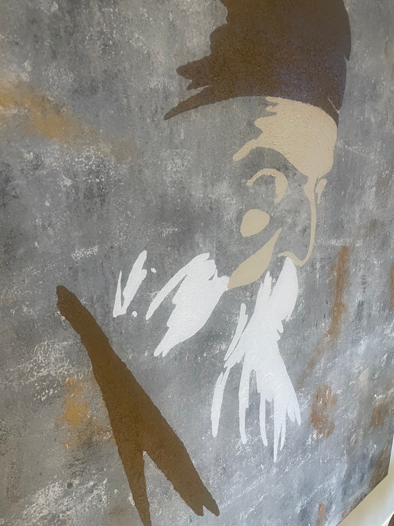 May include: A gray, textured background with a white silhouette of a person's face and beard. The person is wearing a brown hat. The silhouette is painted in a brushstroke style.