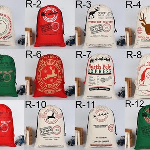 May include: Twelve different Christmas gift bags with various designs. The bags are made of natural canvas fabric and feature red, green, and white colors. Some bags have reindeer, Santa Claus, and other Christmas-themed illustrations. The bags have a drawstring closure.