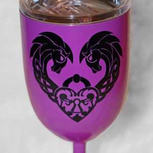 May include: Purple stainless steel wine tumbler with a black design of two intertwined hearts and a keyhole. The tumbler has a lid.