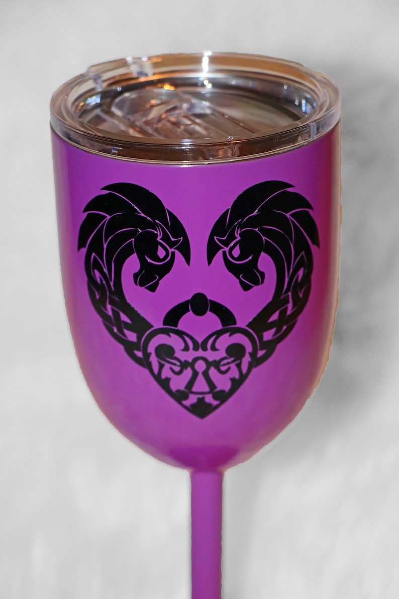 May include: Purple stainless steel wine tumbler with a black design of two intertwined hearts and a keyhole. The tumbler has a lid.