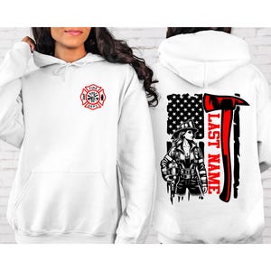 May include: White hoodie with a front pocket and a red and black Fire Dept logo on the front. The back features a firefighter graphic with an American flag and the text "LAST NAME" in red. A firefighter axe is also featured.