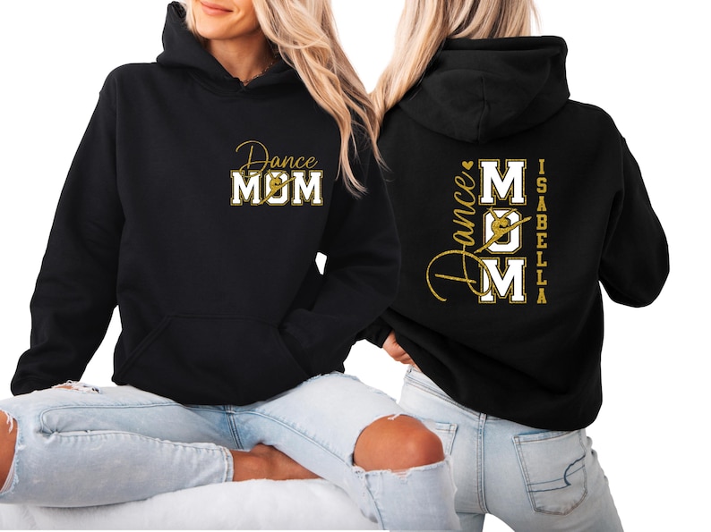 May include: Black hoodie with "Dance MOM" in gold script and block letters on the front. The back features "Dance MOM" with a dancer silhouette and the name "Isabella" in gold. A comfortable, casual top for dance mums.