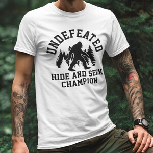 A person wearing a white t-shirt with a graphic design and text printed on it.