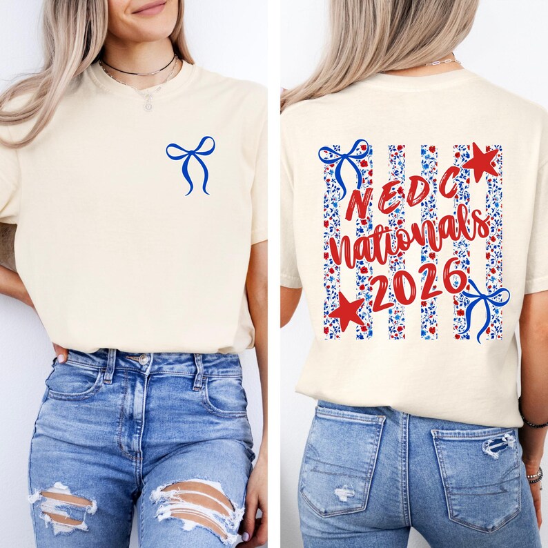 May include: A cream-colored t-shirt featuring a small blue bow graphic on the front left chest. The back displays a large design with vertical stripes, red and blue floral patterns, red stars, blue bows, and the text NEDC nationals 2026.