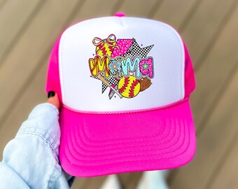 May include: A pink and white trucker hat with a colorful graphic of a softball, bat, and the word "MAMA".