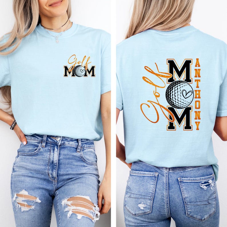 May include: Light blue t-shirt with "Golf Mom" printed on the front and back. The front features the text in black and gold with a golf ball graphic. The back has the text "Golf Mom" and "Anthony" with a golf ball graphic.