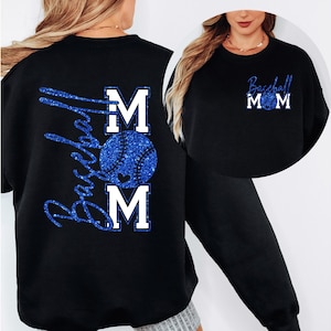 May include: Black sweatshirt featuring a blue glitter baseball design. The design includes the words "Baseball Mom" and a baseball graphic. The letters "MOM" are in white block letters. The sweatshirt is a crew neck style.