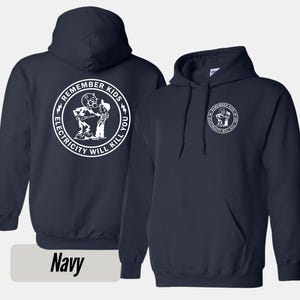 Peut inclure: Sweat-shirt à capuche bleu marine avec une poche avant et un cordon de serrage. Le dos du sweat-shirt présente un motif circulaire blanc avec le texte "REMEMBER KIDS ELECTRICITY WILL KILL YOU". L'avant a une version plus petite du même motif.