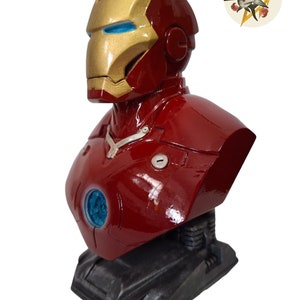 Pu&ograve; includere: Un busto di Iron Man rosso e dorato. Il busto &egrave; realizzato in un materiale lucido e liscio e presenta un design dettagliato. Il busto &egrave; su una base nera.