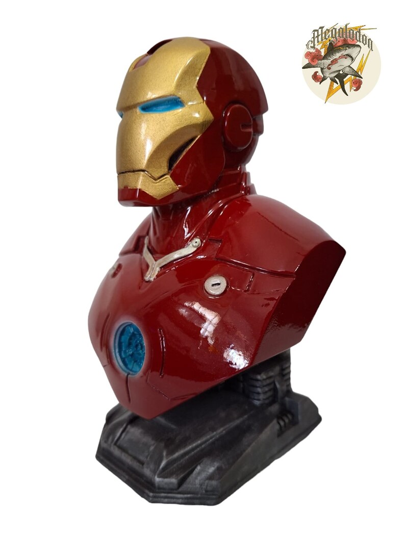 Pu&ograve; includere: Un busto di Iron Man rosso e dorato. Il busto &egrave; realizzato in un materiale lucido e liscio e presenta un design dettagliato. Il busto &egrave; su una base nera.