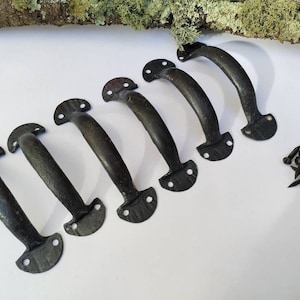 May include: Six dark bronze cabinet handles with a curved design, each with a textured grip and mounting plates with two holes. A small pile of black screws is included. The handles are arranged on a white surface.