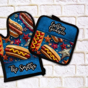 May include: A set of two blue oven mitts with a hot dog and star pattern. The larger mitt has the text "The Smiths" on it. The smaller mitt has the text "Grilling Goodness" on it.