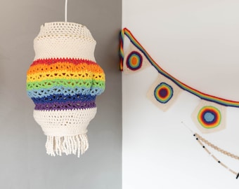 May include: A rainbow crocheted lampshade with white fringe hangs from the ceiling. A rainbow crocheted garland with colorful circles hangs on the wall.