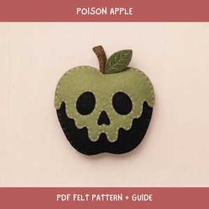 May include: A felt craft project titled POISON APPLE PDF FELT PATTERN + GUIDE. The image shows a green and black felt apple with a skull-shaped cutout design, a brown stem, and a green leaf with stitched details, featuring visible light-colored stitching.