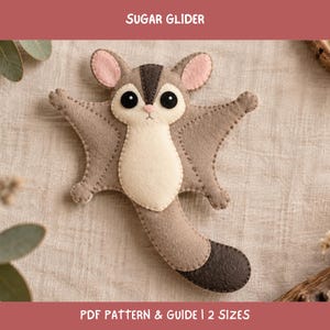 Può includere: Un manufatto in feltro a forma di petaurino dello zucchero con pelliccia marrone chiaro e crema, grandi occhi neri e orecchie rosa. Il testo SUGAR GLIDER e PDF PATTERN & GUIDE | 2 SIZES è visibile. Presenta una lunga coda con punta marrone scuro.