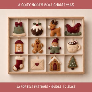 Könnte beinhalten: Eine Holzbox mit zwölf Filz-Weihnachtsanhängern: Glocke, Pudding, Rentier, Schlitten, Laterne, Lebkuchenmann, Elf, Tasse, Socke, Briefumschlag, Haus und Tannenbaum. Der Text auf dem Bild lautet A COSY NORTH POLE CHRISTMAS.