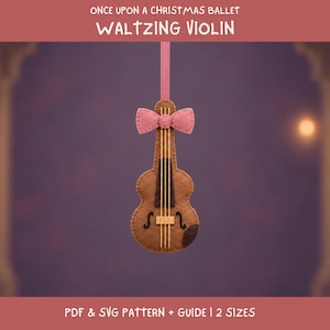 May include: A brown felt violin ornament featuring a pink bow at the top, four vertical strings, and a dark brown fingerboard. The text reads: ONCE UPON A CHRISTMAS BALLET WALTZING VIOLIN PDF & SVG PATTERN + GUIDE | 2 SIZES.